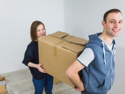 cheerful-couple-carrying-box_23-2147782382